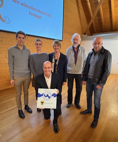 Der Gemeinderat und Christophe Chavanne mit dem Label für Zweisprachigkeit